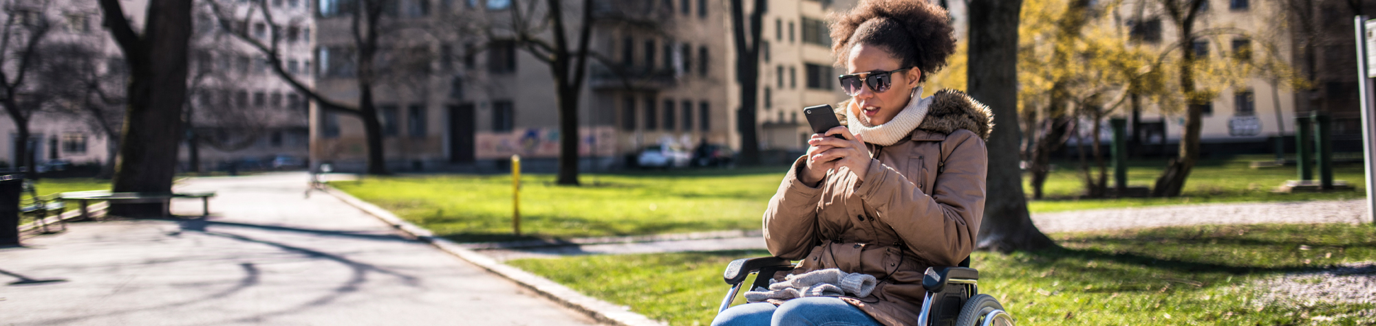 Woman in wheelchair reviewing disability insurance on her phone