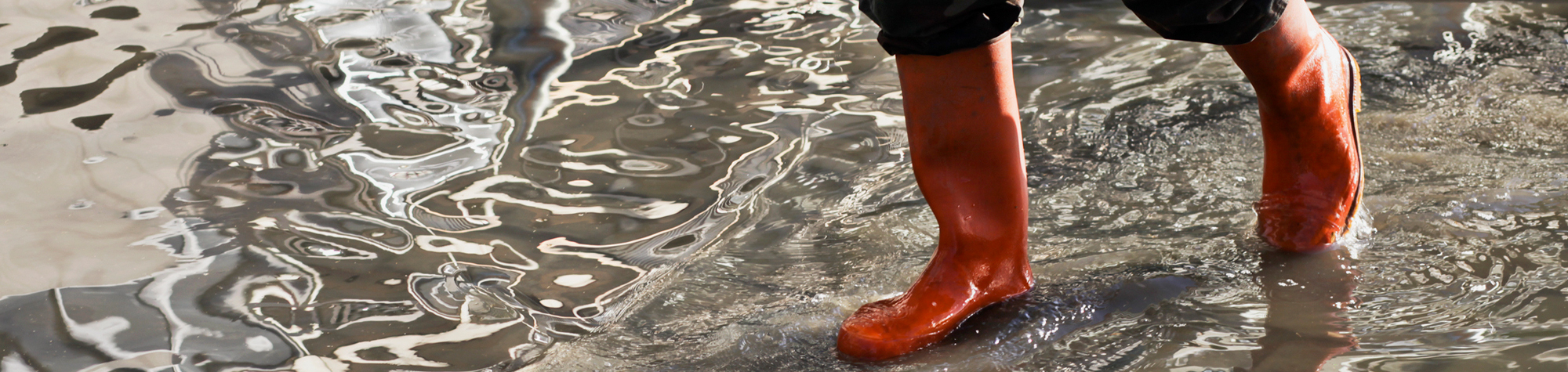 Walking in water wearing red boots