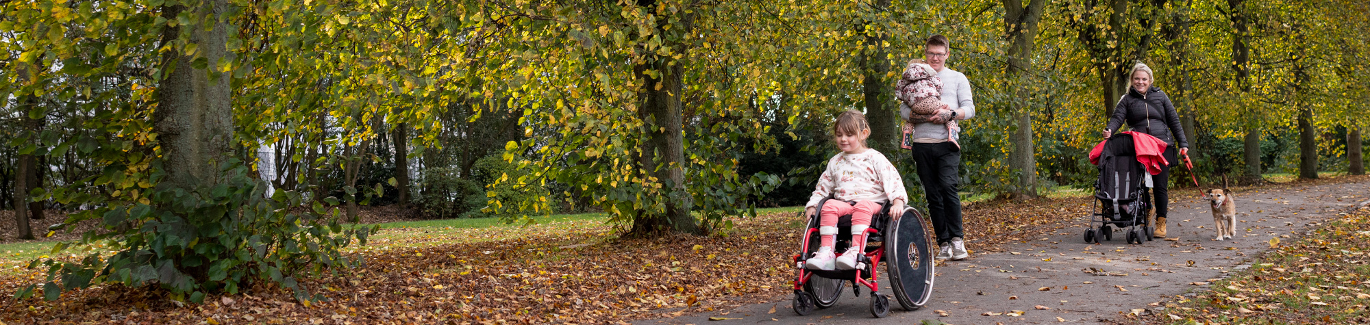 Family walking with girl in wheelchair